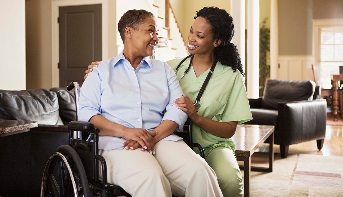 Nurse with woman in wheelchair at home